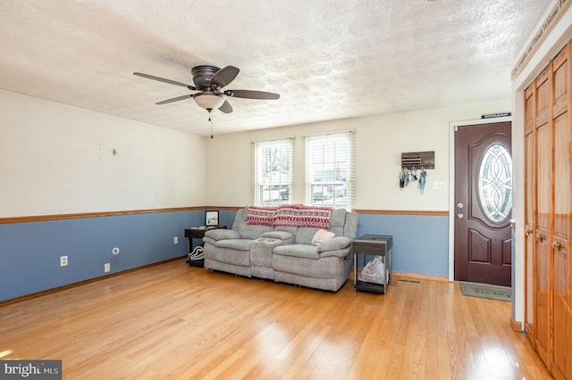 living room featuring a textured ceiling, ceiling fan, and hardwood / wood-style flooring