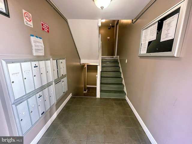 stairway with tile patterned floors and mail boxes