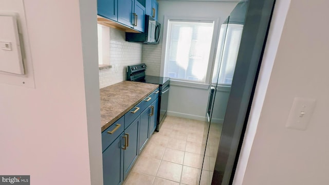 kitchen with blue cabinets, black range with electric stovetop, light tile patterned floors, and backsplash