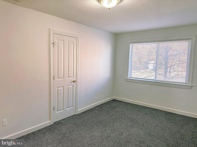 unfurnished room with dark carpet