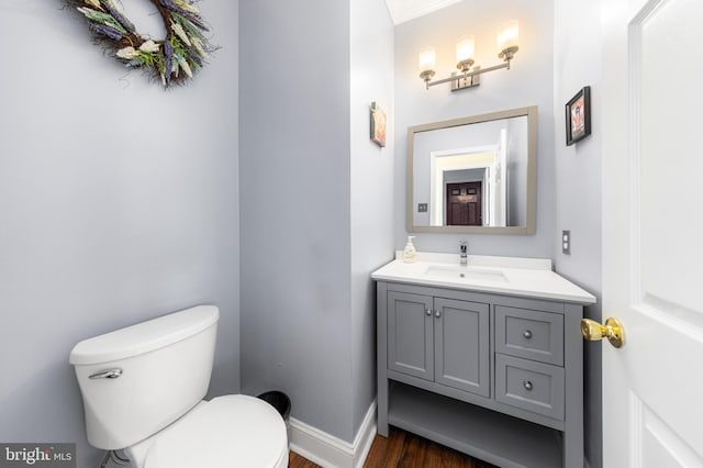 bathroom with wood-type flooring, vanity, and toilet