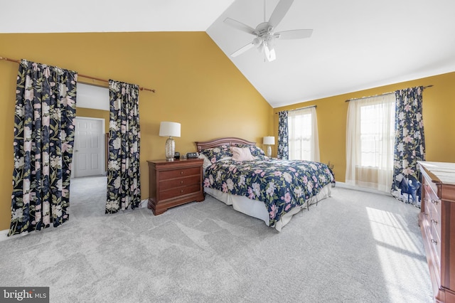 carpeted bedroom with ceiling fan and high vaulted ceiling