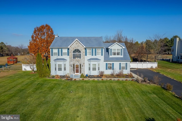 colonial inspired home with a front lawn