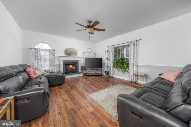 living room featuring wood-type flooring, ceiling fan, and a healthy amount of sunlight