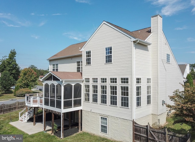 back of property with a sunroom, a patio, and a deck