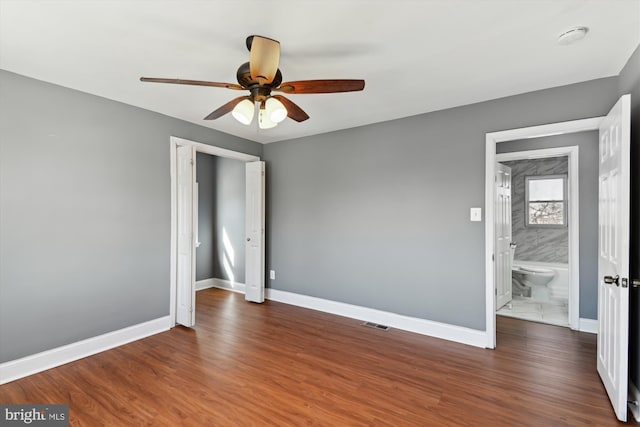 unfurnished bedroom with a ceiling fan, visible vents, baseboards, and wood finished floors