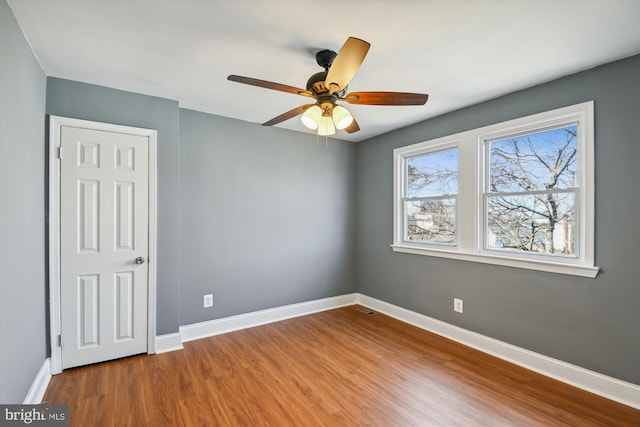 unfurnished bedroom with ceiling fan, baseboards, and wood finished floors