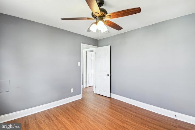 unfurnished room featuring ceiling fan, baseboards, and wood finished floors