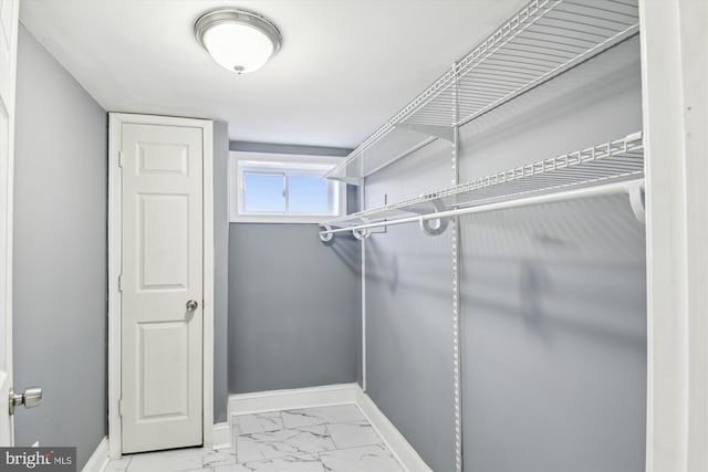 spacious closet featuring marble finish floor