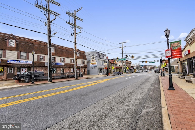 view of street featuring street lighting, curbs, sidewalks, and traffic lights