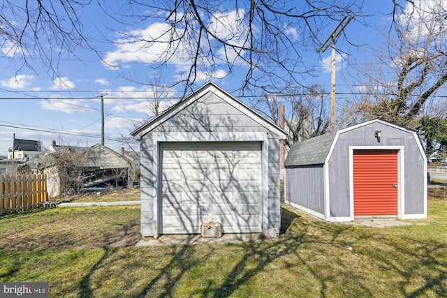 view of shed featuring fence and driveway