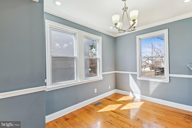 unfurnished dining area featuring ornamental molding, visible vents, and baseboards