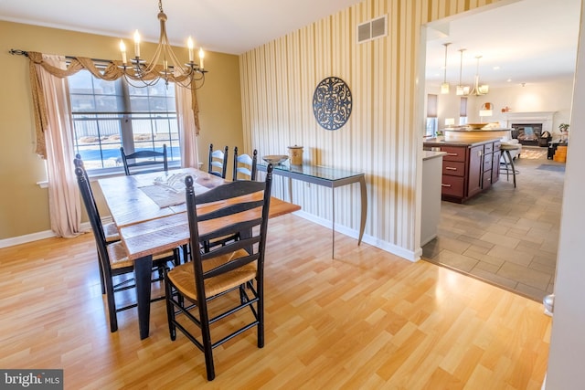 dining area featuring light wood-type flooring and a notable chandelier