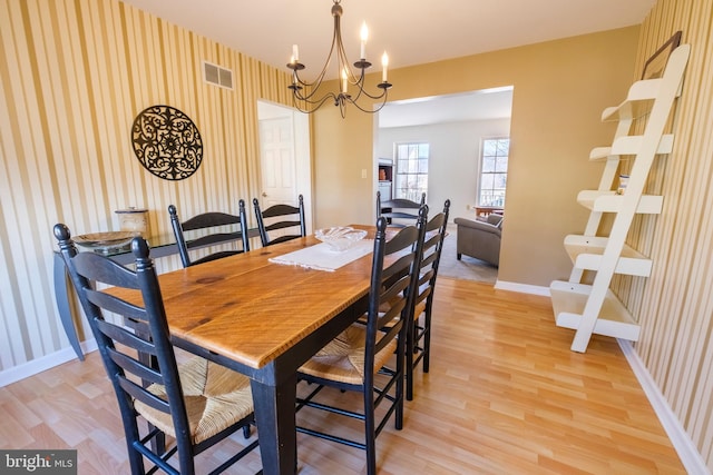 dining area featuring light wood-type flooring and a chandelier