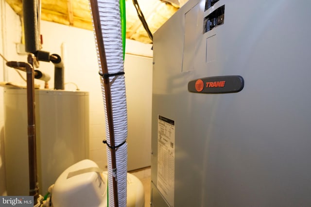 utility room featuring heating unit and gas water heater