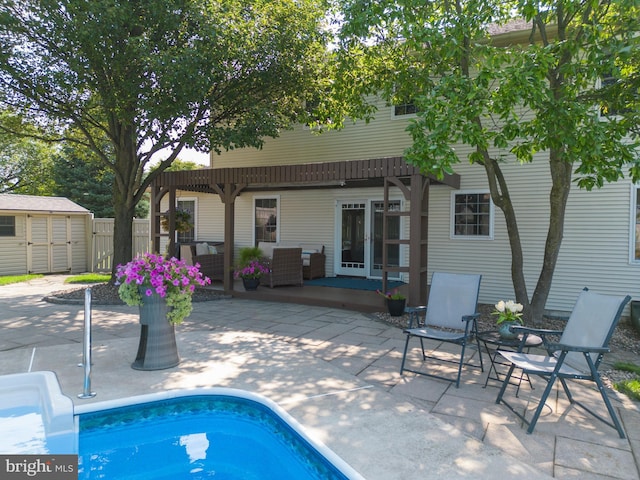 view of pool with a patio area, a pergola, and a storage shed