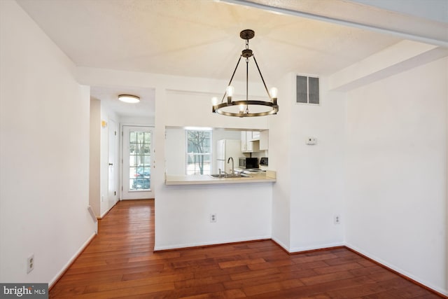 kitchen featuring white refrigerator, sink, pendant lighting, and dark hardwood / wood-style flooring