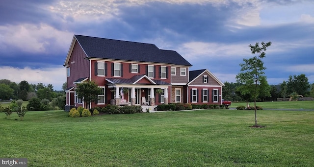 colonial inspired home featuring a porch and a front yard