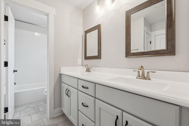 full bathroom with tiled shower / bath combo, vanity, tile patterned flooring, and toilet