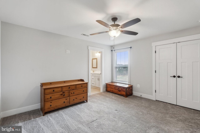 bedroom featuring ceiling fan, light colored carpet, ensuite bathroom, and a closet