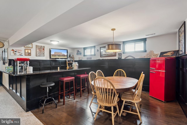 dining room featuring bar and dark wood-type flooring