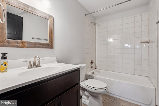 full bathroom with tile patterned flooring, vanity, tiled shower / bath combo, and toilet