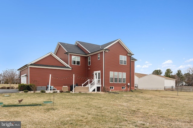 rear view of property featuring a garage, central AC unit, and a lawn