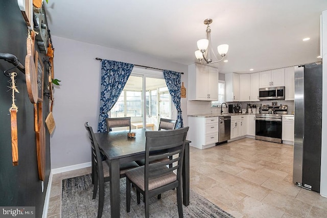 dining space featuring sink and an inviting chandelier