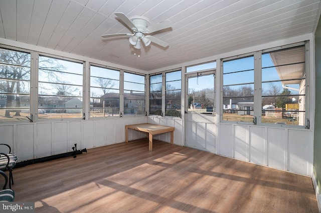 unfurnished sunroom featuring ceiling fan, a healthy amount of sunlight, and wood ceiling