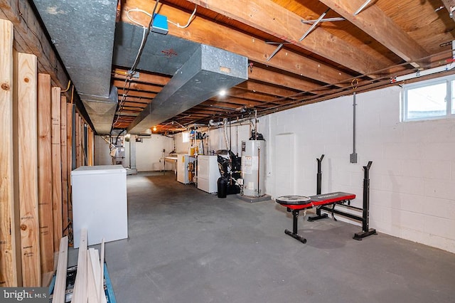 basement with refrigerator, gas water heater, and washing machine and clothes dryer