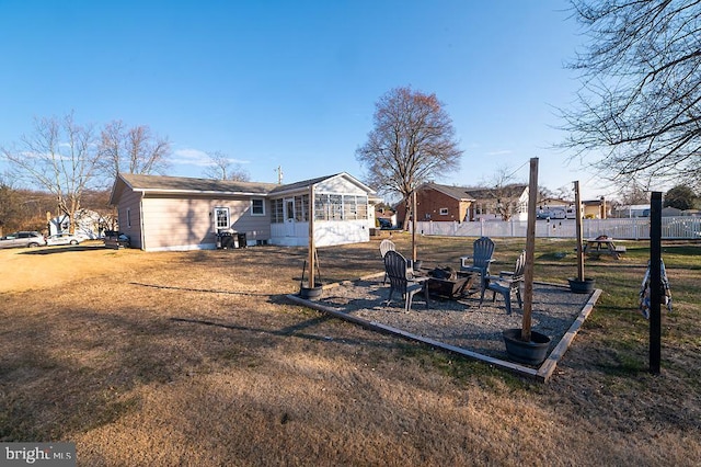 back of property featuring a lawn and a fire pit