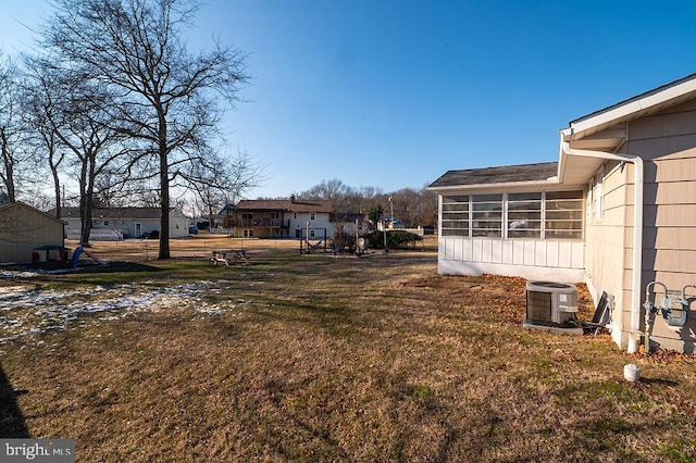 view of yard featuring central AC and a sunroom