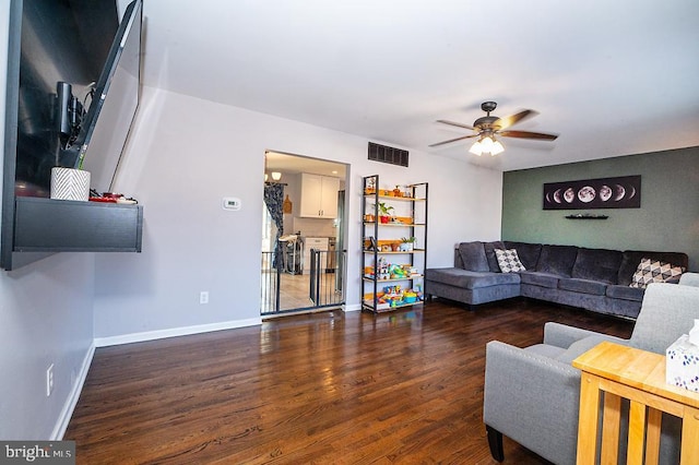 living room with ceiling fan and dark wood-type flooring