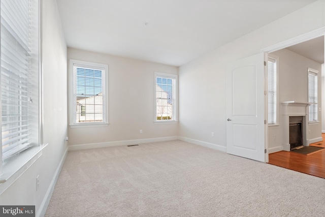 carpeted spare room featuring plenty of natural light