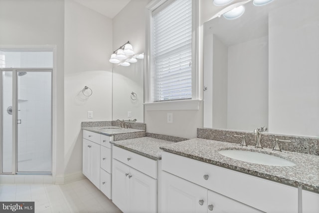 bathroom featuring a shower with door, vanity, and tile patterned flooring