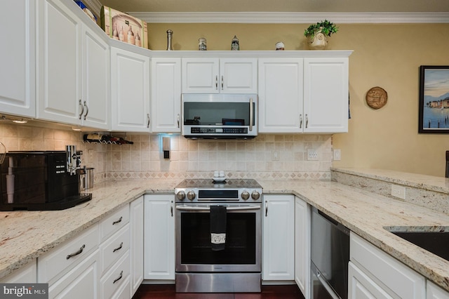 kitchen with white cabinetry, ornamental molding, light stone counters, and appliances with stainless steel finishes