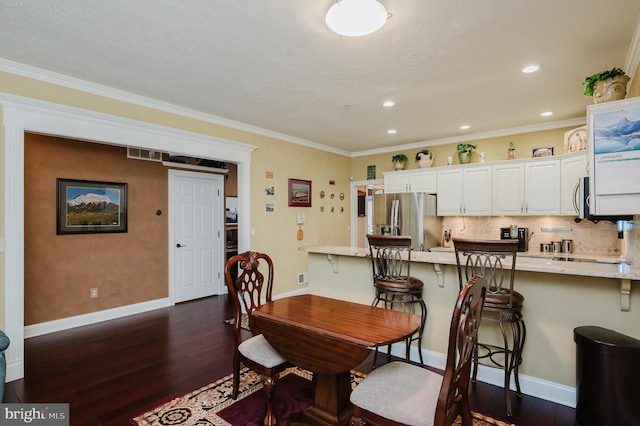 dining room featuring crown molding and dark hardwood / wood-style floors