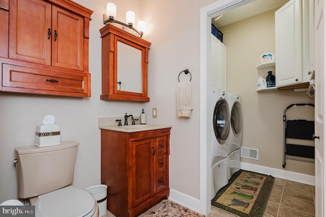 bathroom featuring toilet, vanity, and separate washer and dryer