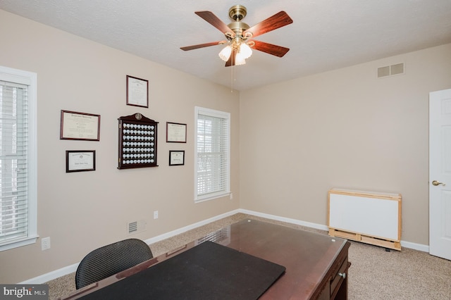 workout area featuring a textured ceiling, ceiling fan, and light colored carpet