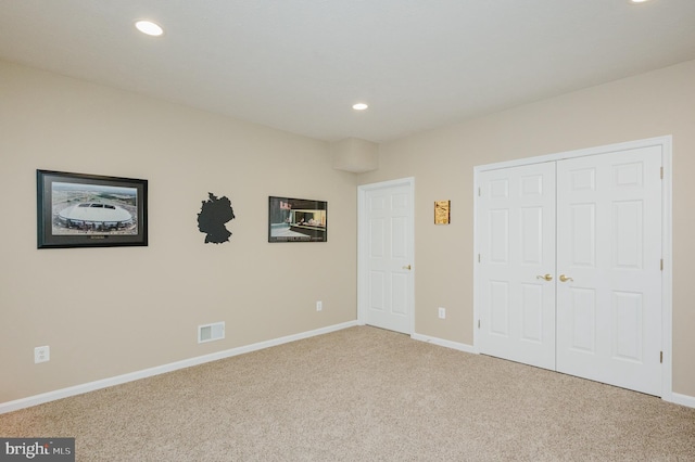 unfurnished bedroom with carpet flooring and a closet