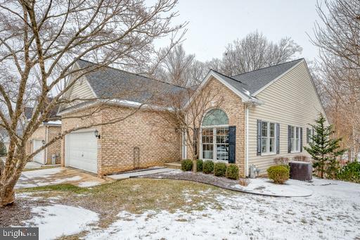 view of front of property with a garage and cooling unit