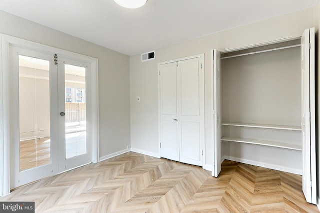 interior space featuring access to exterior, french doors, light parquet flooring, and multiple windows