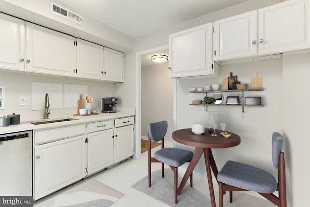 kitchen with white cabinets, stainless steel dishwasher, and sink