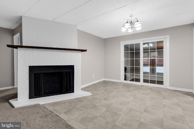 unfurnished living room featuring a fireplace and an inviting chandelier