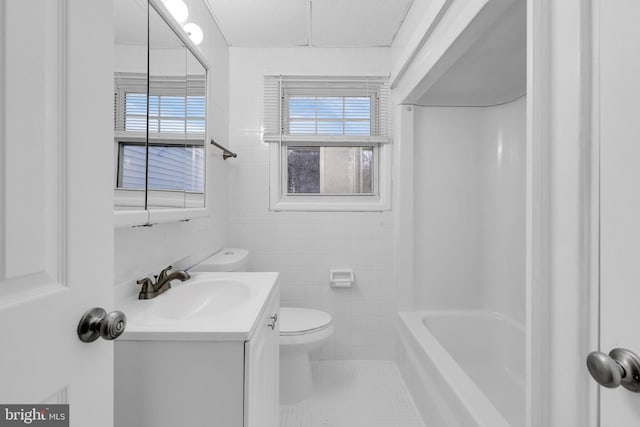 full bathroom featuring vanity, tile patterned floors, toilet, shower / bathing tub combination, and tile walls