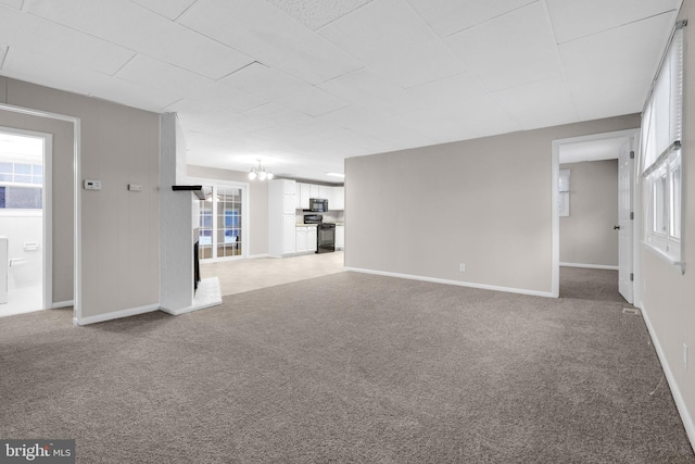 unfurnished living room with light colored carpet and an inviting chandelier