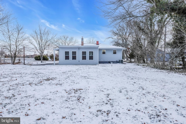 view of snow covered back of property