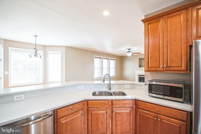 kitchen with sink, decorative light fixtures, stainless steel appliances, and ceiling fan