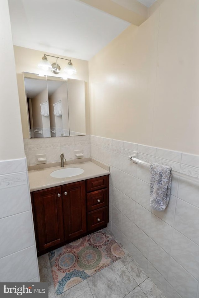 bathroom with tile patterned flooring, vanity, and tile walls