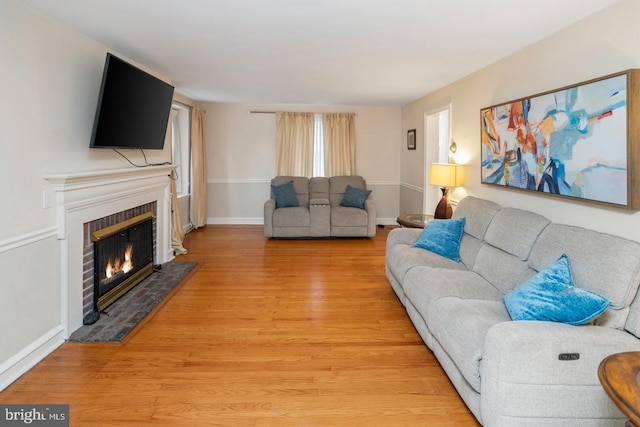 living room with wood-type flooring and a fireplace